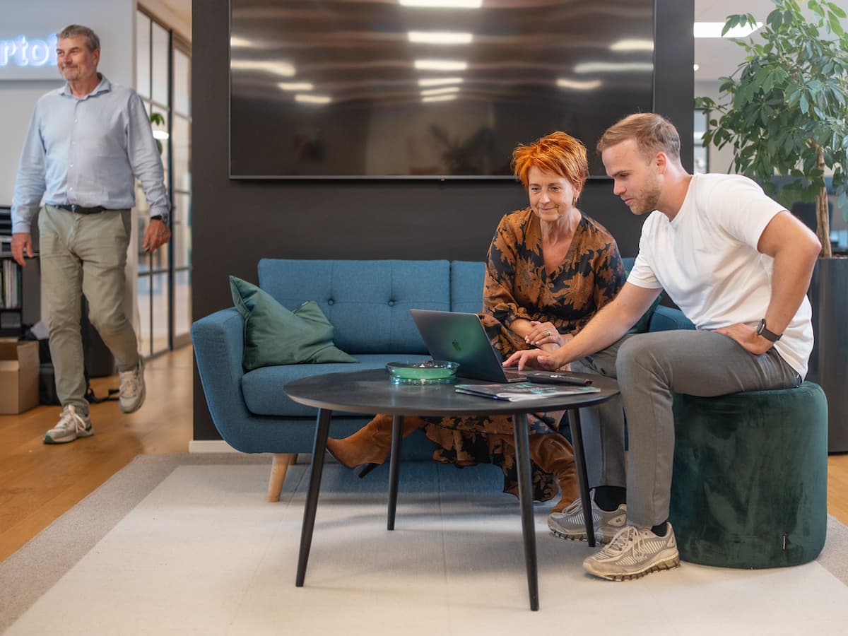 Medarbejdere hos Bording Danmark samarbejder ved laptop i loungeområde